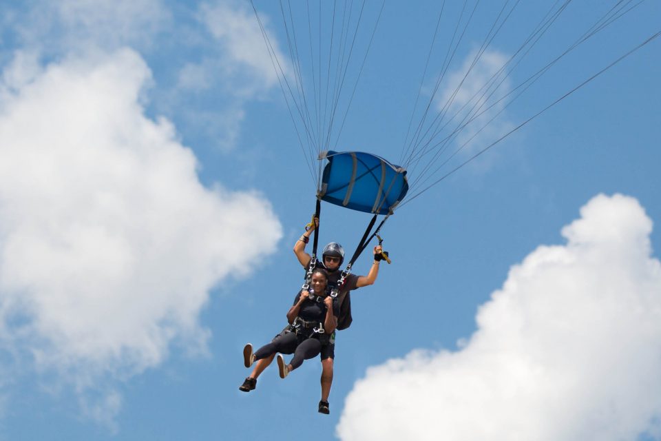 young women floats towards awesome skydive with a skydive the gulf tandem instructor