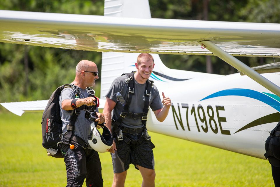 Tandem skydiver and instructor walking towards skydive the gulf aircraft