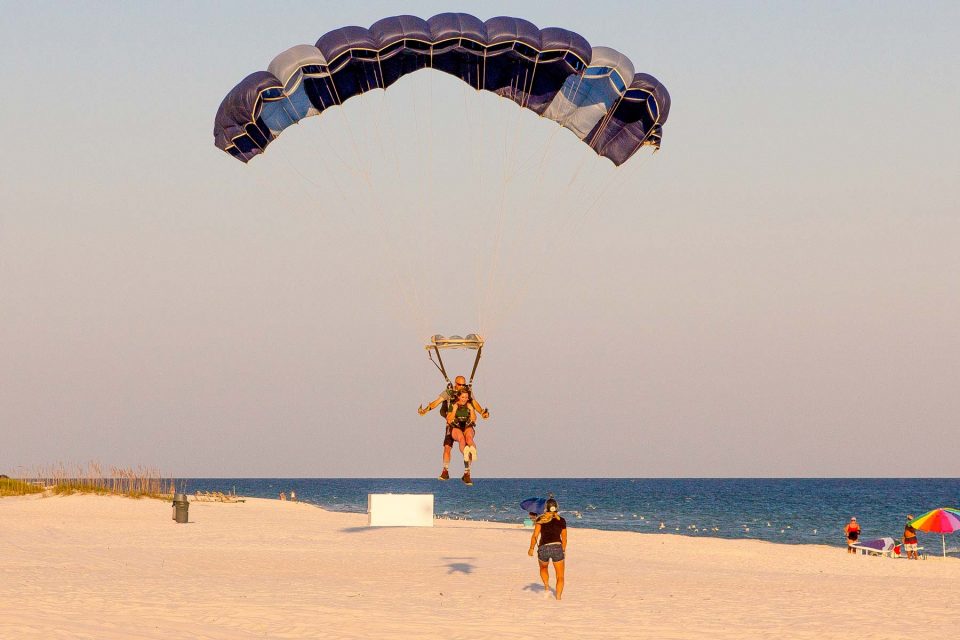 young female comes in for landing on the beach after an amazing skydive over the ocean