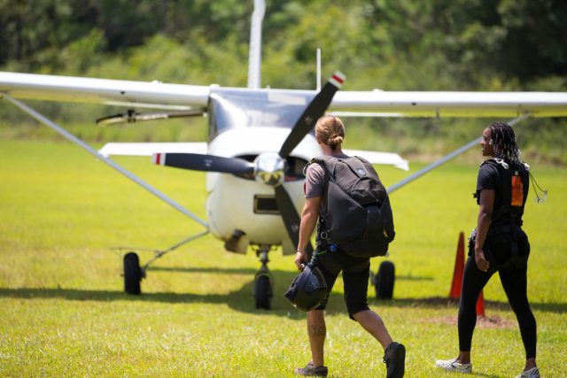 Man and women walk towards the skydive the gulf aircraft before going on a skydive