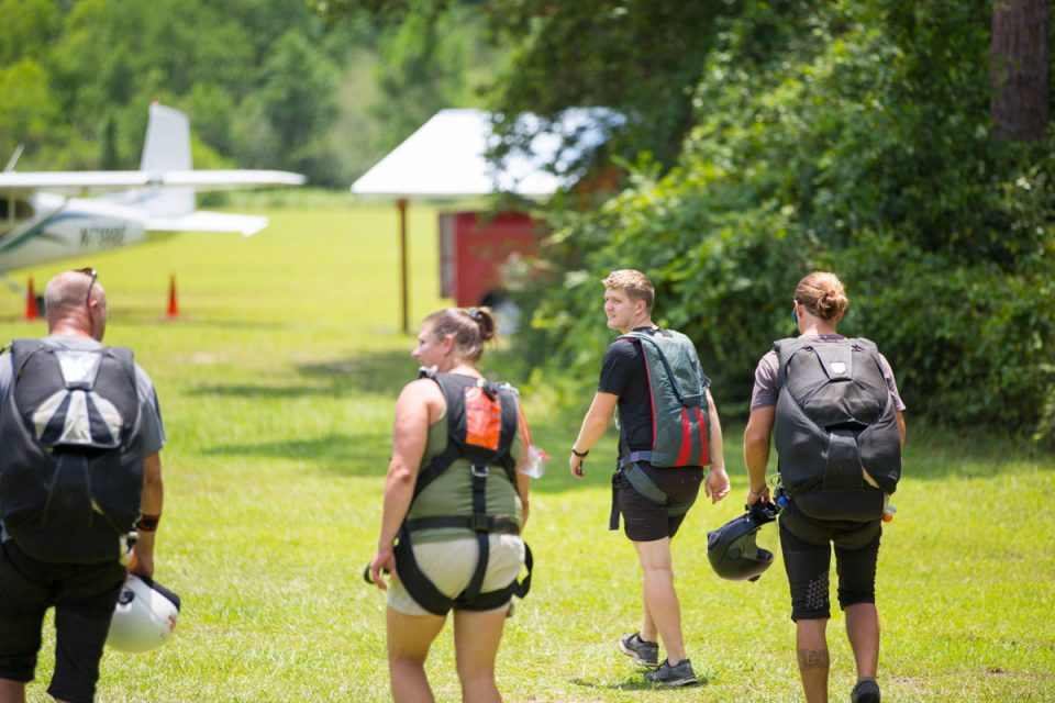 Tandem students and instructors walk towards the skydive the gulf aircraft to go for a skydive