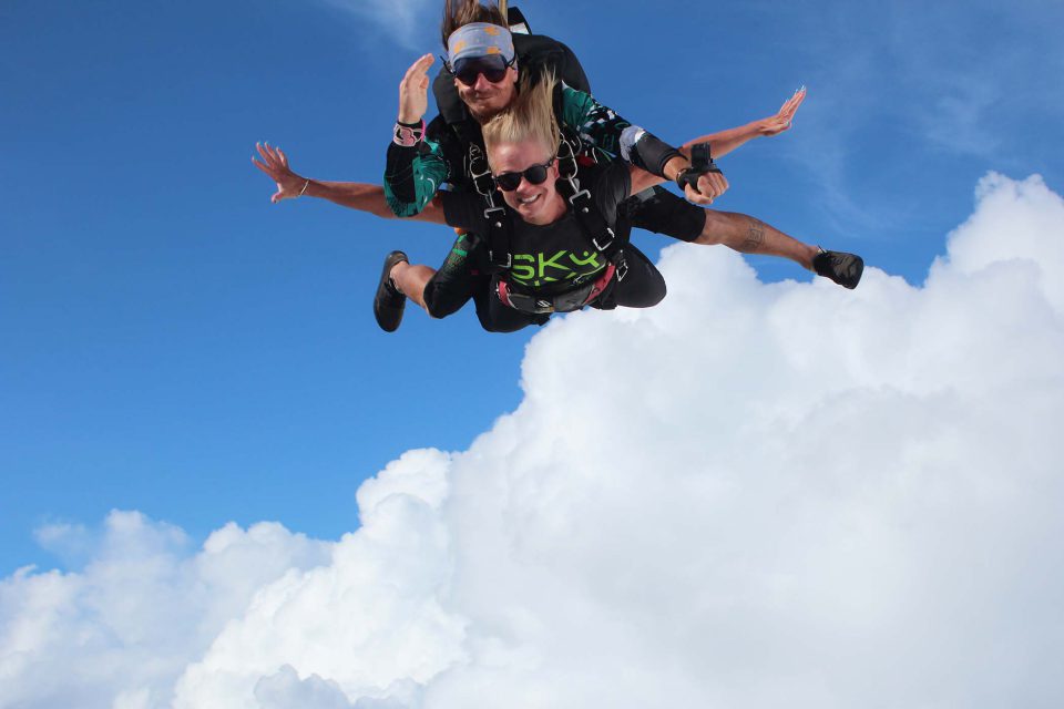 women wearing black shirt and black sunglasses enjoying the rush of free fall